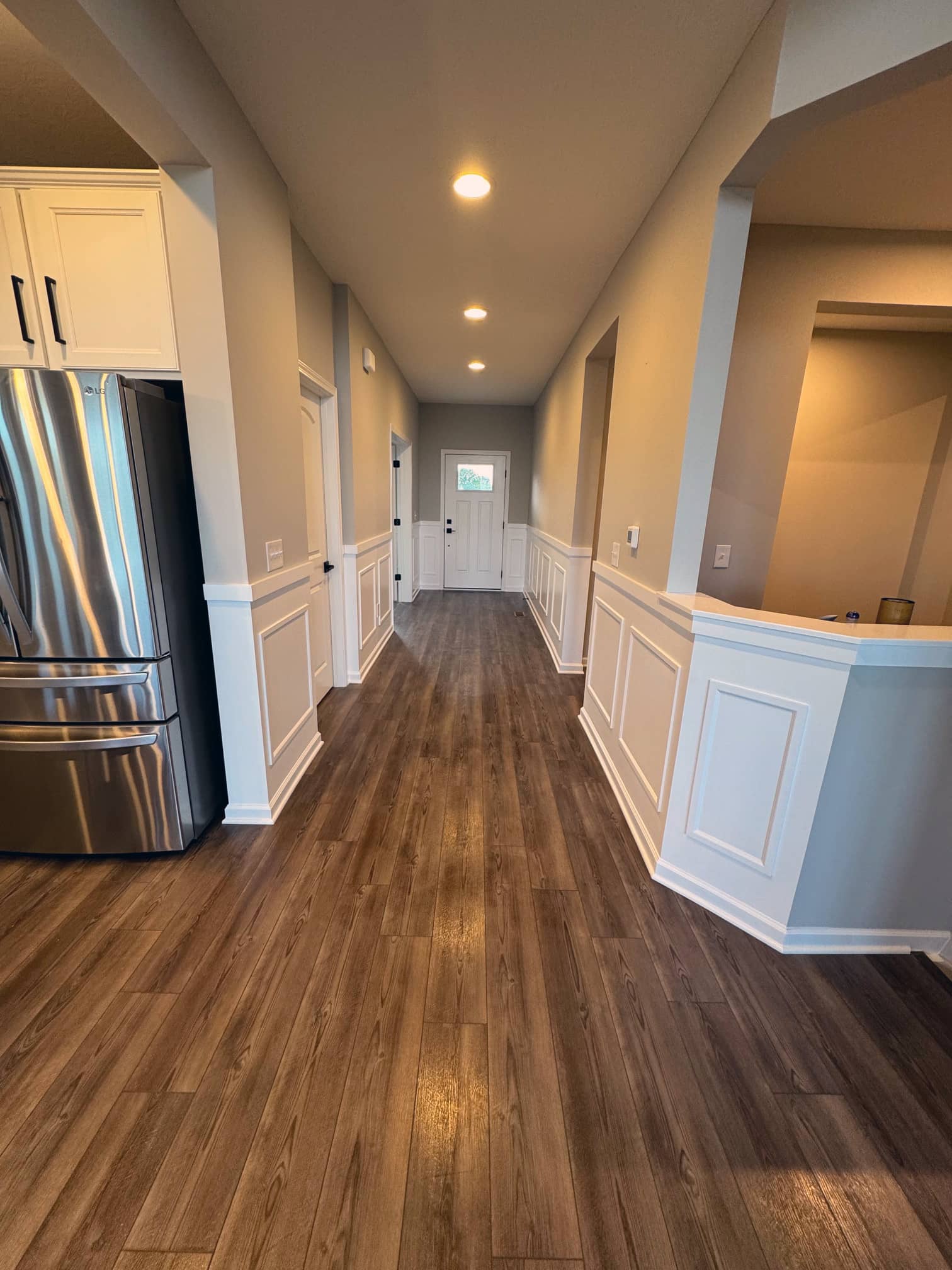 Long interior hallway with recessed lighting and hardwood floors in a Columbus-area residence